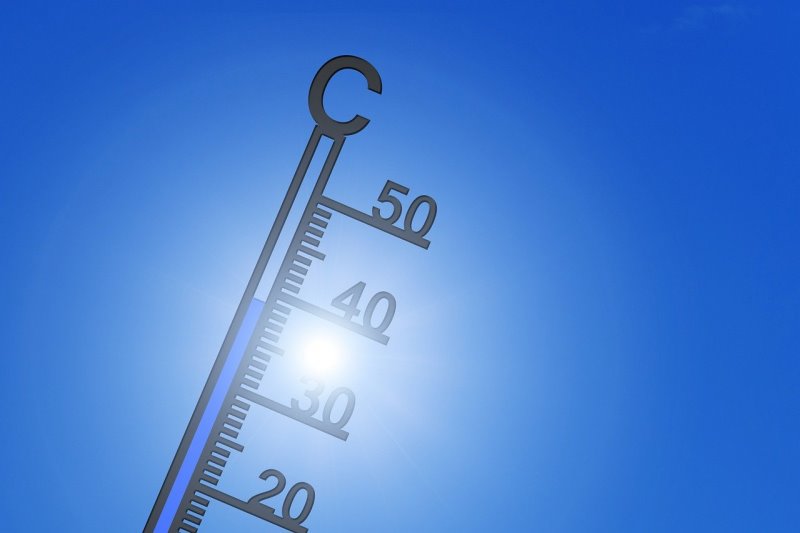 Ein Gartenthermometer glänzt in der Sonne Ein Thermometer mit freistehenden Gradzahlen in der Sonne