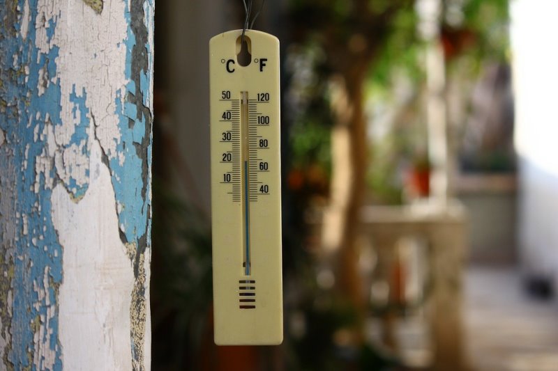 Ein Außenthermometer, das gerade die Temperatur misst Ein Thermometer hängt draußen im Garten