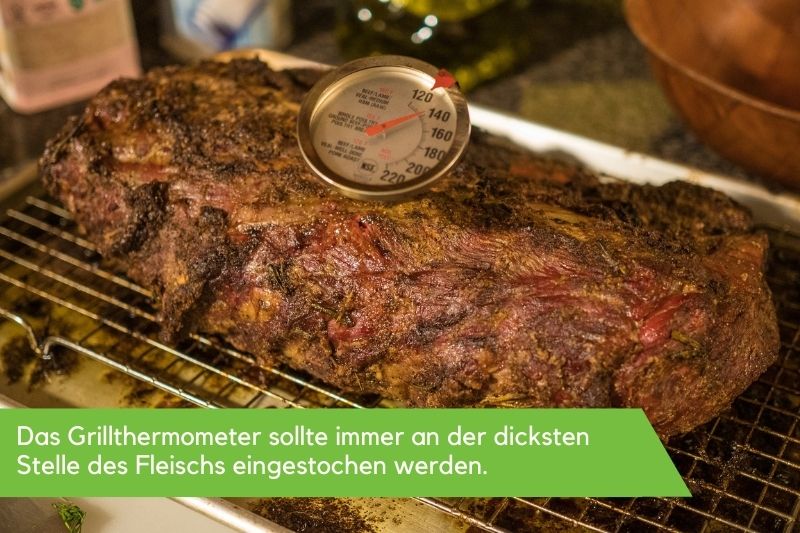 Bratenthermometer, welches in einem Stück Fleisch steckt Bratenthermometer, welches in einem Stück Fleisch steckt