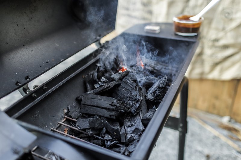Grill mit Holzkohle, die raucht