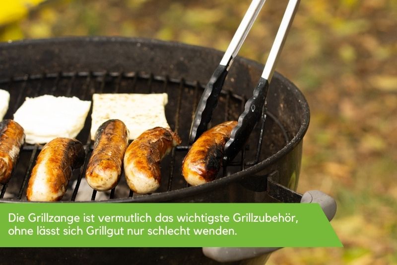 Würstchen auf einem Kugelgrill werden gewendet