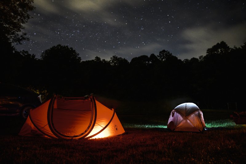 Insekten in der Nacht Zwei erleuchtete Camping-Zelte nachts