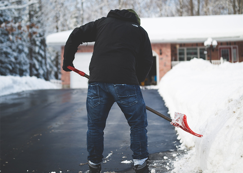 ein Mann schaufelt Schnee