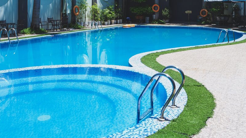 Ein großer Pool mit zwei Poolleitern aus Edelstahl
