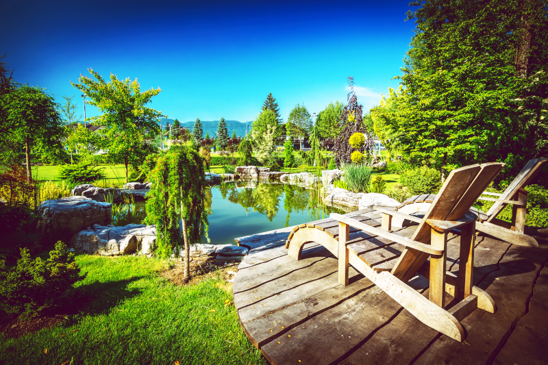 Eine Terrasse mit einem Steg der an einen Teich angrenzt