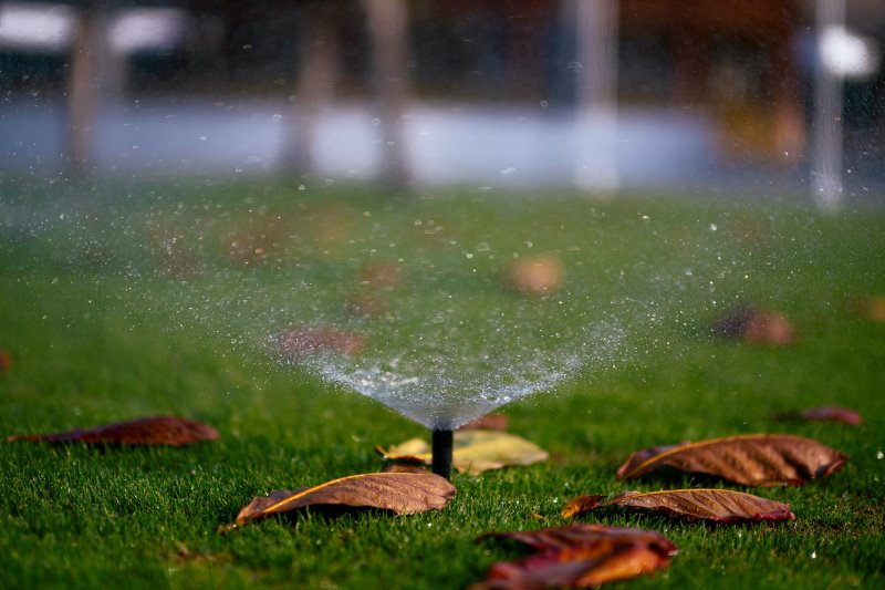 Ein Versenkregner beregnet den Rasen im Herbst