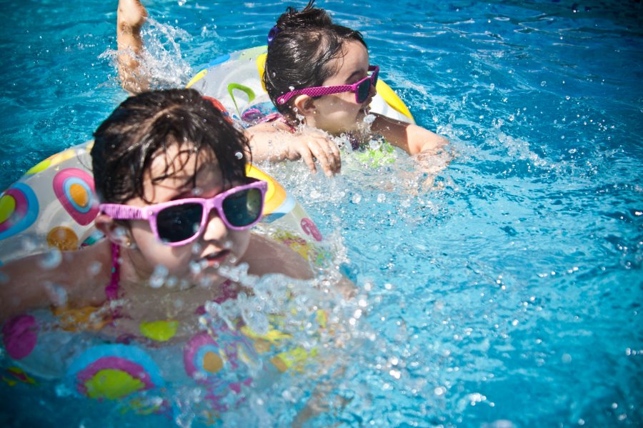 Zwei Mädchen planschen im Pool Kinder im Pool haben Spaß