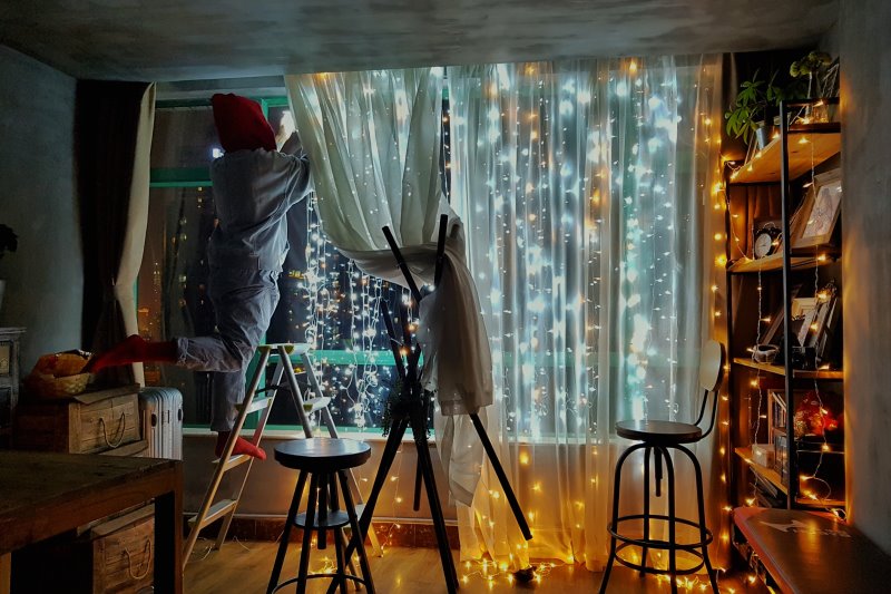 Lichternetz/ Lichtervorhang leuchtet vor einer großen Fensterfront.